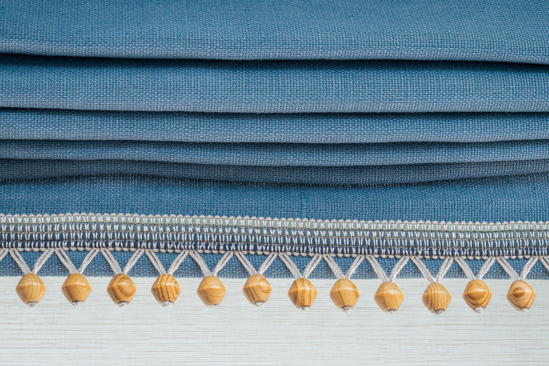 Blue Roman shade detail with wooden bead trim