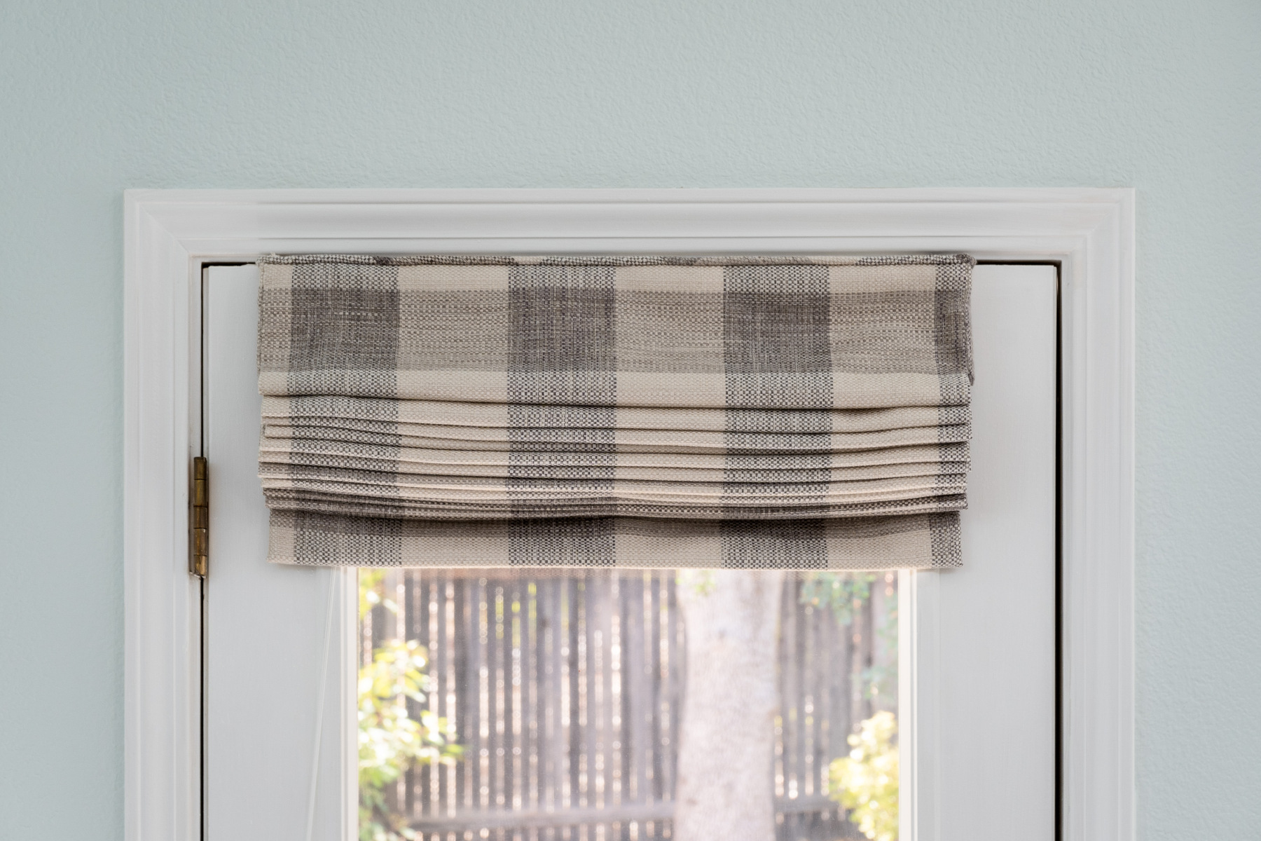 Plaid roman shade on door