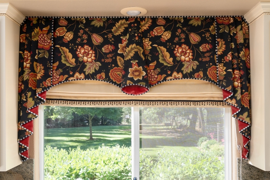 Stylized black floral valance with tan Roman shade